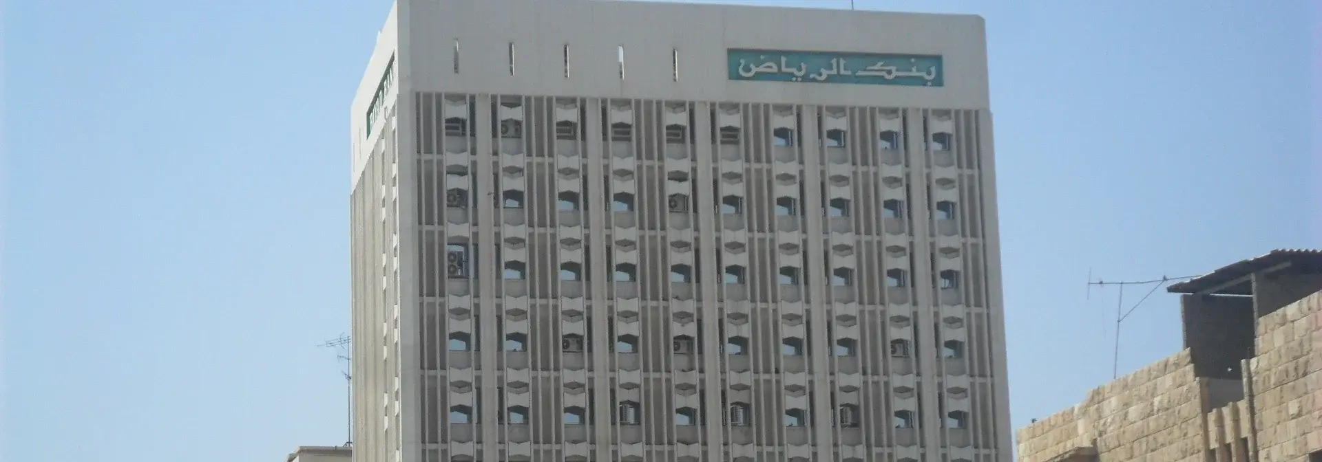 The Riyadh Bank building in Al-Batha district, Riyadh, with the Arabic sign «بنك الرياض» on its upper facade